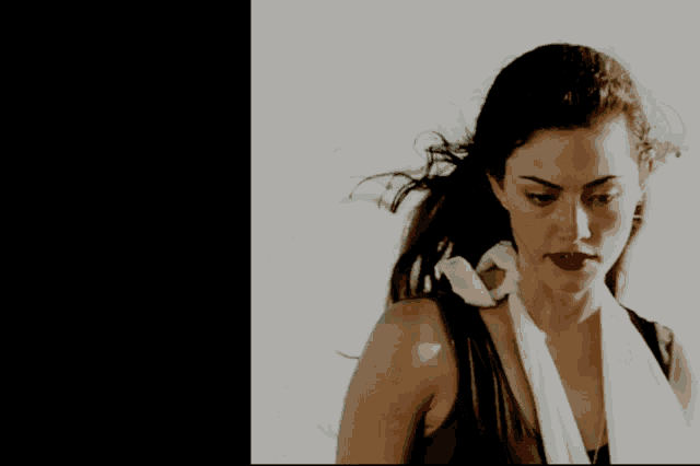a woman with a scarf around her neck looks down