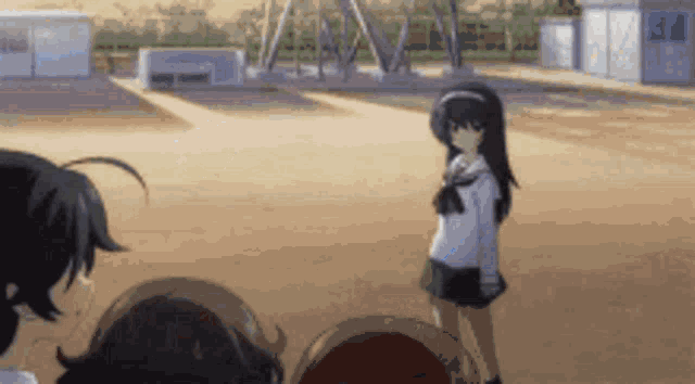 a girl with long black hair is standing in a field with other people .