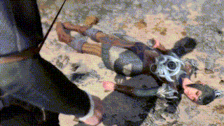 a man in a knight 's armor is laying on the ground in the sand .