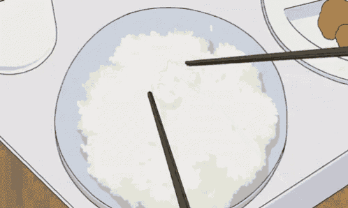 a plate of white rice with chopsticks on it