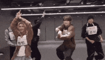 a group of young men are dancing in a room .