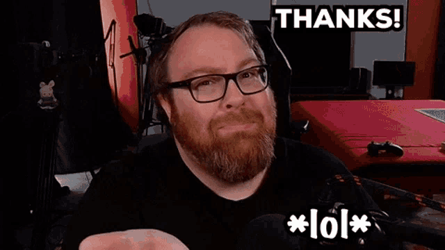 a man with glasses and a beard is smiling and says thanks lol