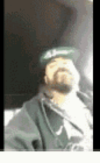 a man with a beard is wearing a green hat and a green jacket .