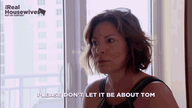 a woman says " please don 't let it be about tom " in front of a window