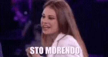 a woman is standing in front of a microphone with the words sto morendo written on the screen .