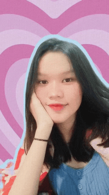 a girl with her hand on her face in front of a pink and blue heart