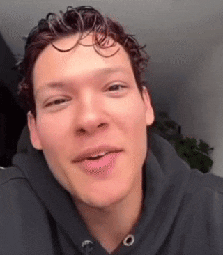 a close up of a man 's face with a black hoodie on .