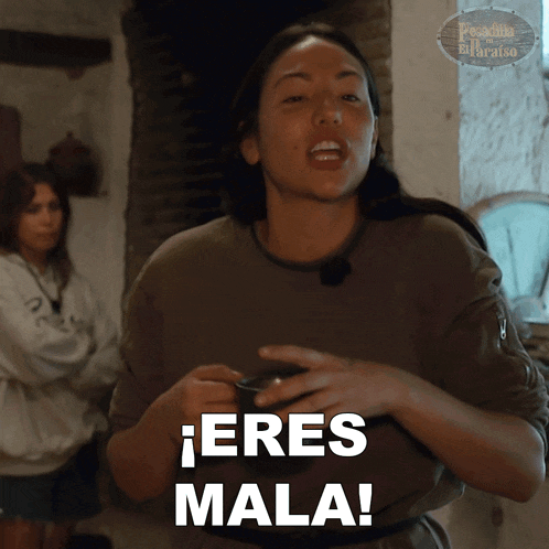 a woman holding a cup with the words eres mala written on it