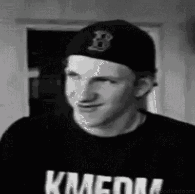 a black and white photo of a man wearing a hat and a shirt that says kmedia