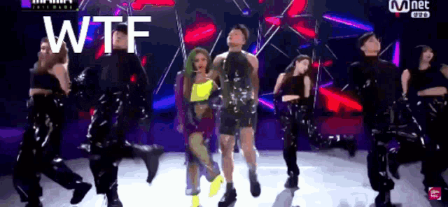 a group of people are dancing on a stage and the words wtf are visible
