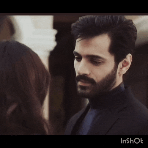 a man with a beard is looking at a woman in a video that says inshot