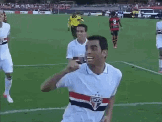 a group of soccer players are running on the field and one of them has the number 8 on his jersey