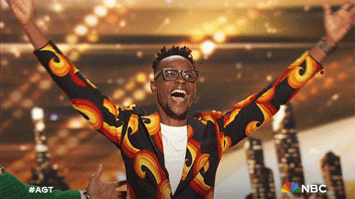 a man with his arms in the air with the nbc logo in the background