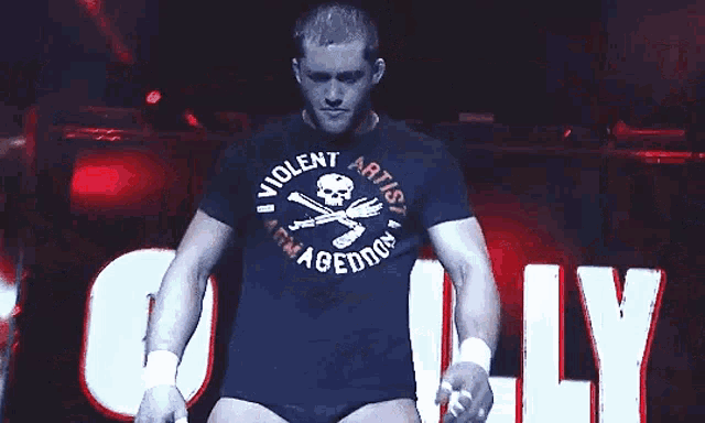 a man wearing a shirt that says violent artist is standing on a stage
