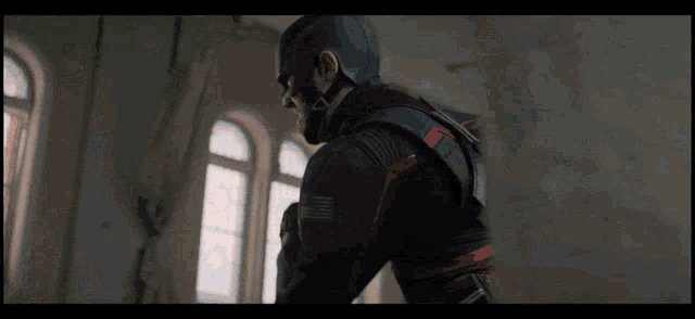 a man in a superhero suit is standing in a room