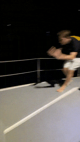 a man in a black shirt and white shorts jumps off a boat