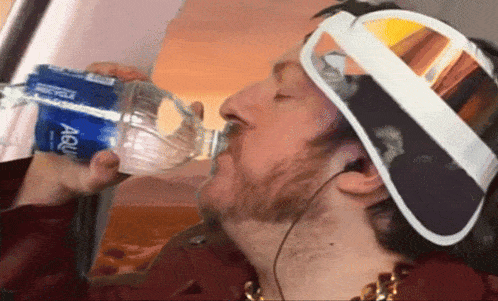 a man drinking from a bottle that says aqua on it