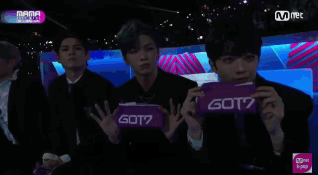 a group of young men are holding a sign that says got7 on it