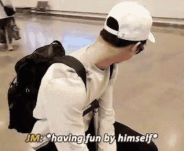 a man wearing a white hat and a backpack is having fun by himself .
