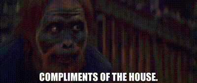 a close up of a zombie with the words `` compliments of the house '' written on it .