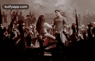 a man and a woman are dancing in front of a crowd of people in a club .