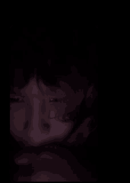 a close up of a person 's face with a dark background