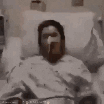 jesus is sitting in a hospital bed eating a meal .