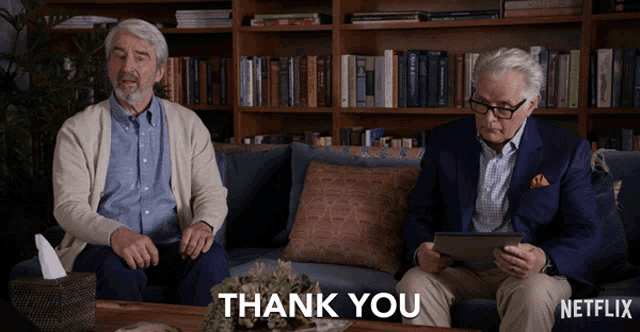 two older men sit on a couch with a netflix logo on the bottom right