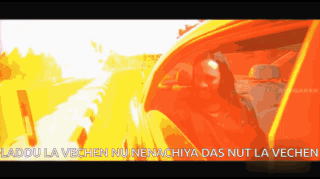 a man is driving a car with the words " laddu la vechen nu nenachiya das nut la vechen " on the bottom