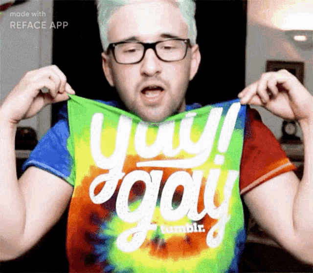 a man wearing glasses and a tie dye shirt that says yay gay