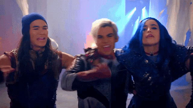 a group of people are standing next to each other and one of them has blue hair