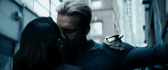 a man and a woman are kissing in an alleyway .