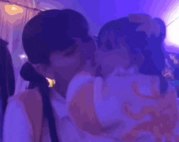a woman is kissing a baby in a blurry photo