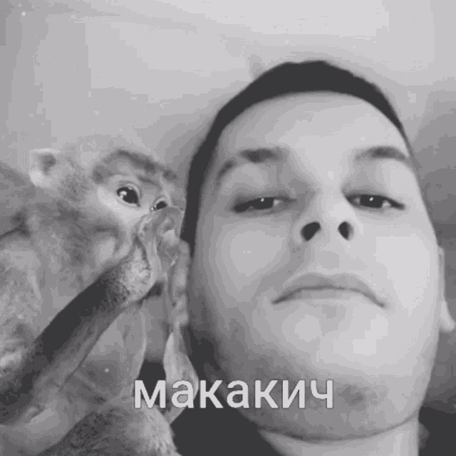 a black and white photo of a man and a monkey with the word makakich written on his face