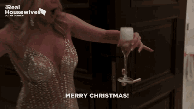 a woman in a sequined dress is holding a glass of champagne and wishing merry christmas
