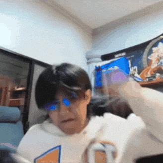 a person wearing glasses and a white shirt with the letter t on the front