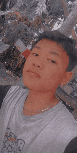 a young boy wearing a gray shirt with the letter g on it