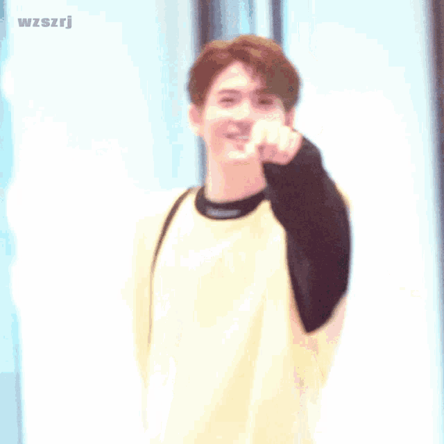 a young man is singing into a microphone with the words wzszrj written on the bottom