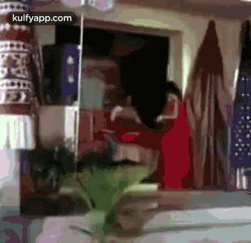 a blurry picture of a woman in a red dress standing in front of a window .