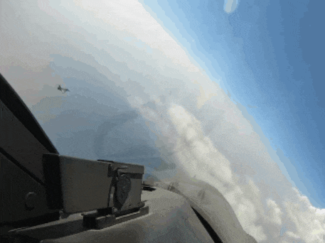 a plane is flying through a cloudy sky with a camera on the side of the plane