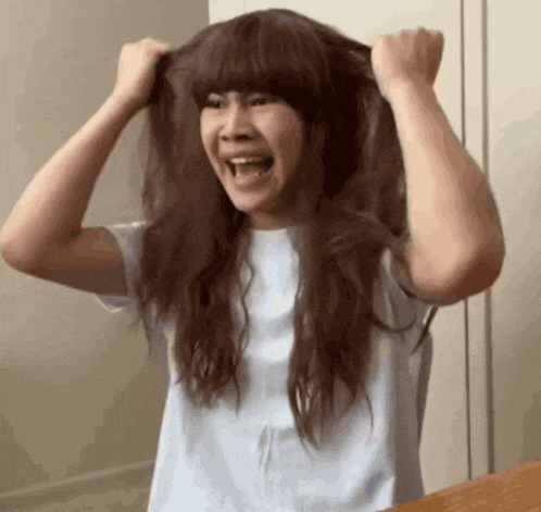 a woman wearing a wig is making a funny face .