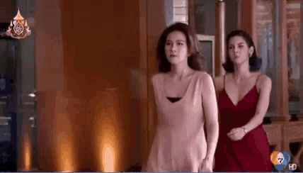 two women in red dresses are standing next to each other in front of a tv screen that says 7 hd on it