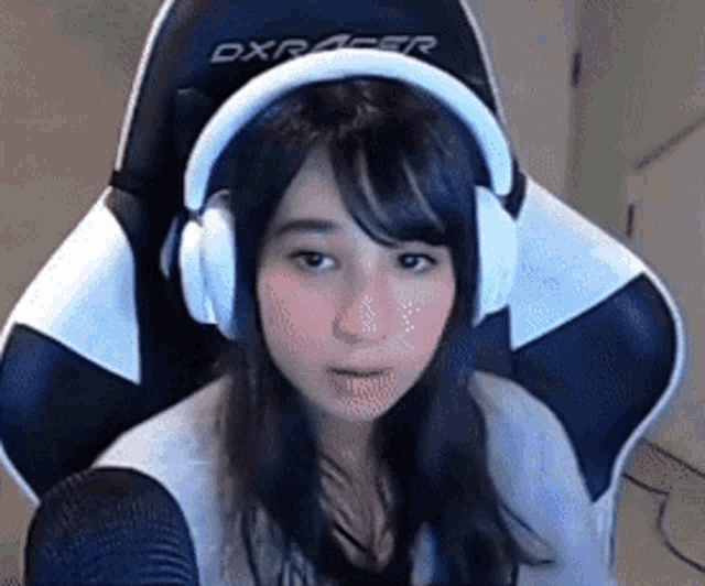 a woman is wearing headphones and sitting in a chair .