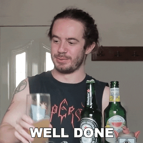 a man in a black shirt holds a glass of beer in front of a bottle of amstel beer