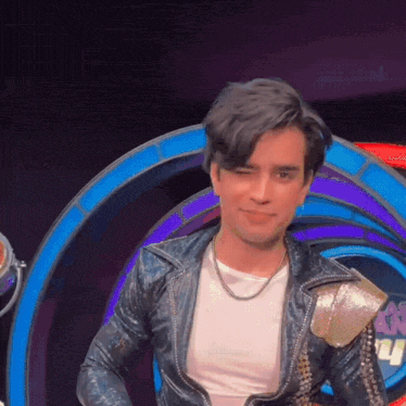 a young man in a leather jacket and white shirt is smiling