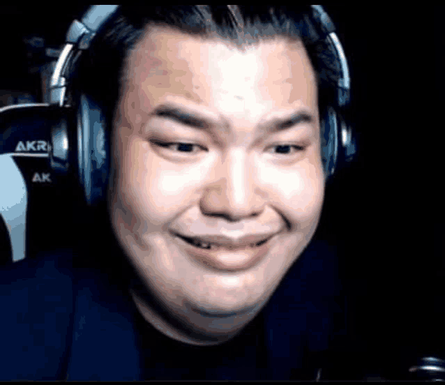 a man wearing headphones is making a funny face while looking at the camera .