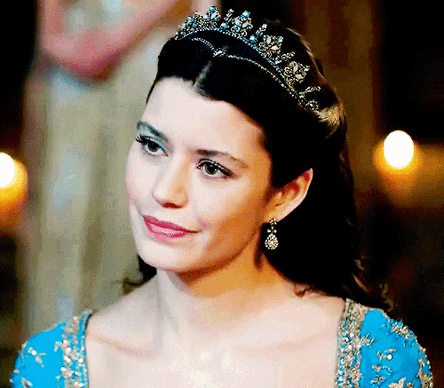 a woman wearing a tiara and a blue dress