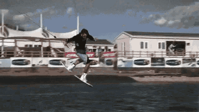 a man is jumping in the air while riding a wakeboard