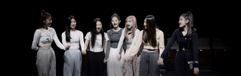 a group of girls are standing next to each other with their arms in the air .