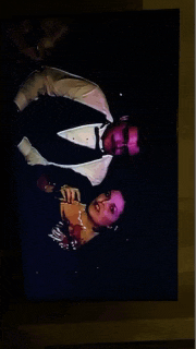 a man in a tuxedo and a woman in a dress are on a tv screen